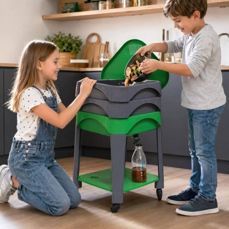 Two children putting peelings into a City Worms wormery in the kitchen